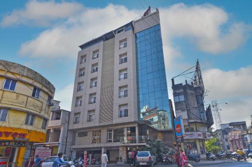 a tall building with glass windows on a city street at Hotel SRI SRI EXECUTIVE KOLHAPUR NEAR MAHALAXMI TEMPLE in Kolhapur