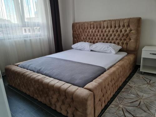 uma cama grande com uma cabeceira acolchoada num quarto em Loft Palace Suit em Nevşehir