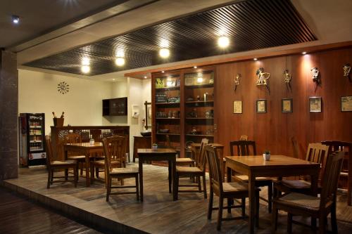 een restaurant met tafels en stoelen in een kamer bij COZY Boutique Guest House in Malang