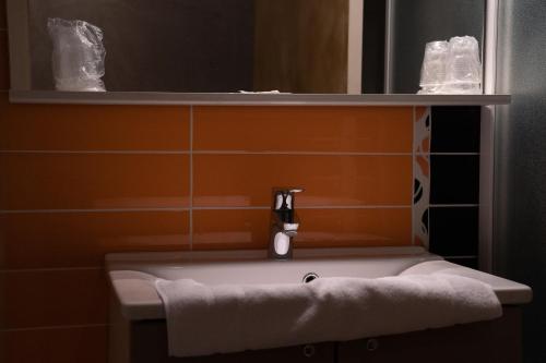 a bathroom with a white sink and a mirror at LA FERME D'ANDRE 