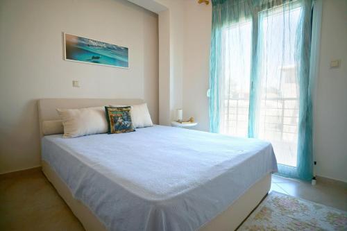 a bedroom with a large bed with a large window at Makridis Summer Villas in Paralía Avdhíron