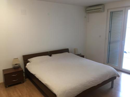 a bedroom with a bed and a large window at Home Apartment Petrovac in Petrovac na Moru