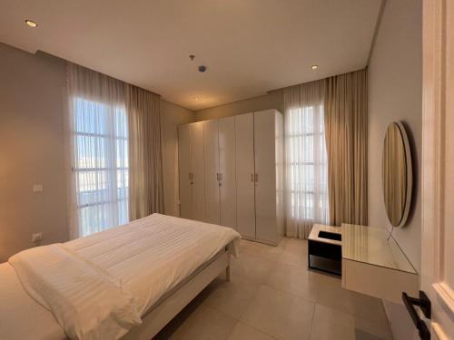 a bedroom with a bed and a desk and windows at luxury 3BD Condo Near the Boulevard in Riyadh