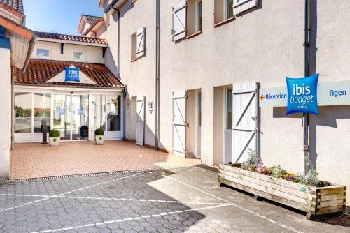 a building with a bus ride sign in front of it at Ibis Budget Agen in Le Passage