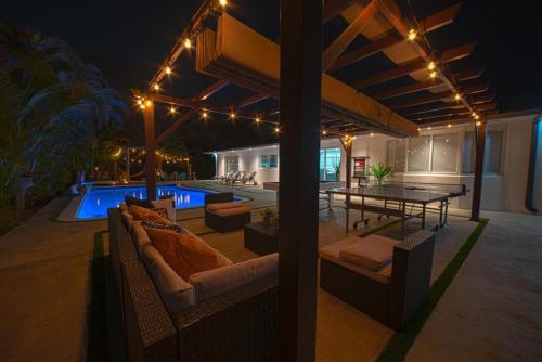 a patio with a table and a pool at night at Heated pool in a Precious House close to Zoo Parks and Arts in Cutler Bay