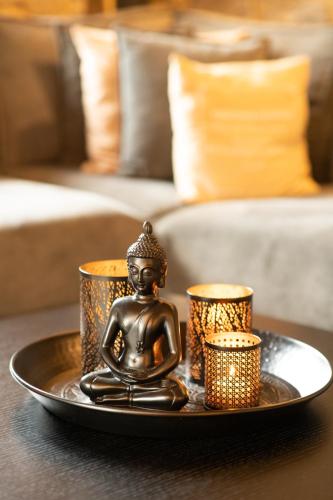 a tray with a buddha statue and candles on a table at Villa MYLOS Kalavrita in Kalavrita