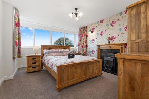 a bedroom with a bed and a fireplace at Comfy Cumbrian Stay in Distington