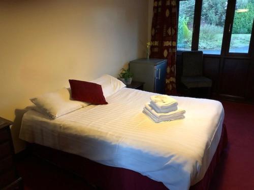 a bed with towels and a laptop on top of it at Clare House in Mundford