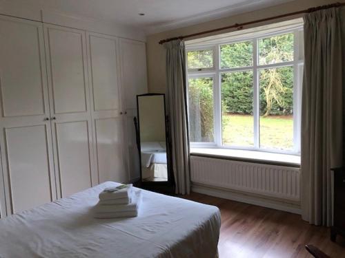 a bedroom with a bed and a large window at Clare House in Mundford