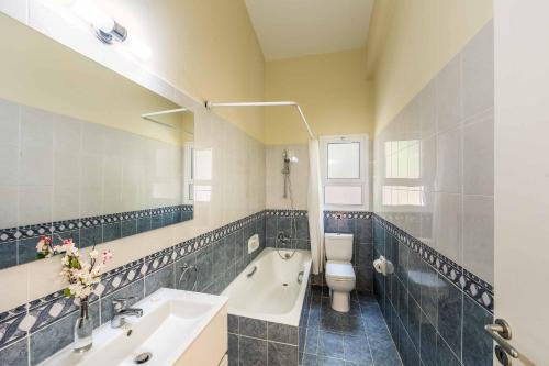Un baño con bañera, inodoro y lavabo. en Villa Kefalonitis, en Peyia