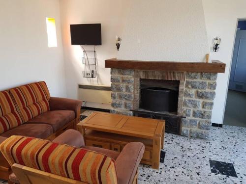 ein Wohnzimmer mit einem Sofa und einem Kamin in der Unterkunft La Grimpette in Châtillon-en-Bazois