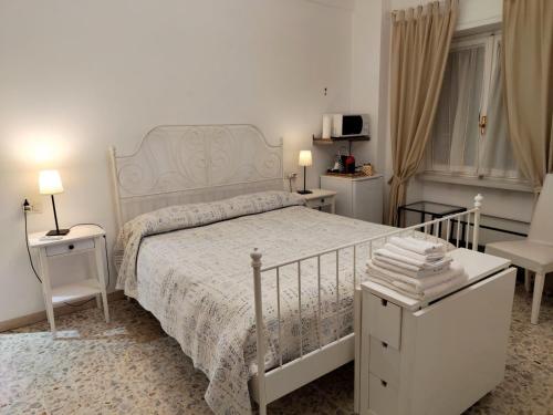 ein weißes Schlafzimmer mit einem Bett und einem Stuhl in der Unterkunft Sergio's Rooms & Studio close Tiburtina Station in Rom
