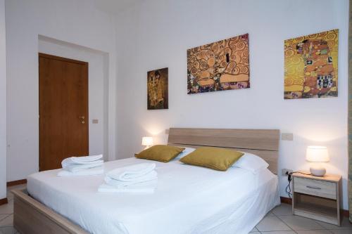 a bedroom with a white bed with towels on it at Casato19 - Due passi da Piazza del Campo - NaonBnB in Siena