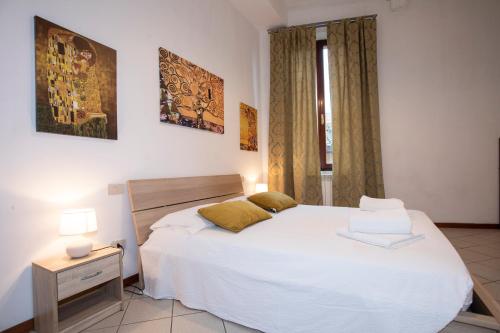 a bedroom with a large white bed and a window at Casato19 - Due passi da Piazza del Campo - NaonBnB in Siena