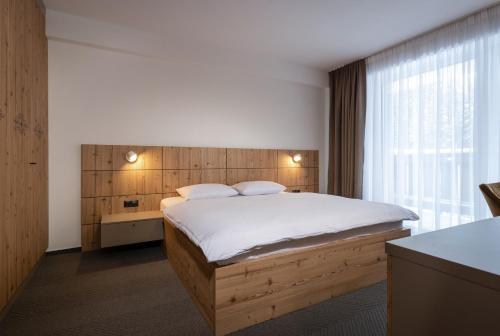 a bedroom with a large bed with a wooden headboard at YOLOJ sk - Garage parking - Ski in Ski Out in Belá