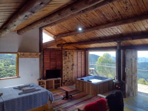 a room with a bed and a tub in a house at Chalés Pôr do Sol in Gonçalves