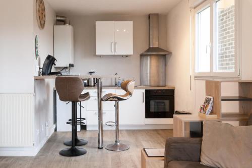 un salon avec une cuisine équipée d'un comptoir et de chaises dans l'établissement TY KERNOGUET - STUDIO - PARKING - WIFI- BALCON, à Vannes