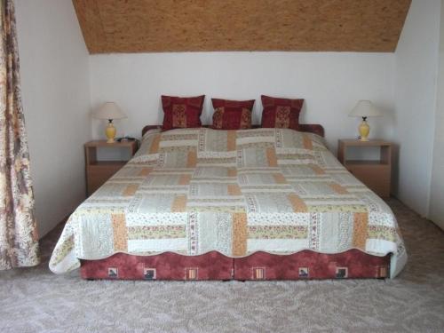 - une chambre avec un grand lit et des oreillers rouges dans l'établissement Ferienhaus mit Terrassen und Balkonen sowie Parkplatz, à Birkamajor