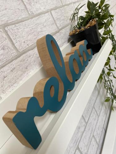 a wooden sign that says faith on a shelf next to a plant at VonAmor Rooms in Novi Sad