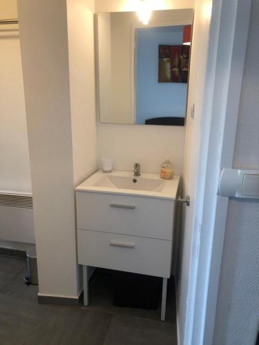 bagno con lavandino bianco e specchio di Appartement cosy proximité plage Malo les bains a Dunkerque