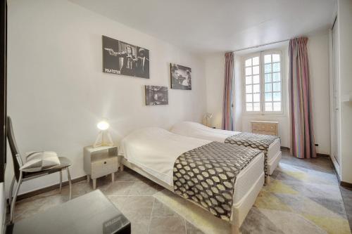 une chambre avec deux lits et une chaise et une fenêtre dans l'établissement 'JOLI 4 Pieces PROCHE VIEUX PORT' - A3B75, à Cannes