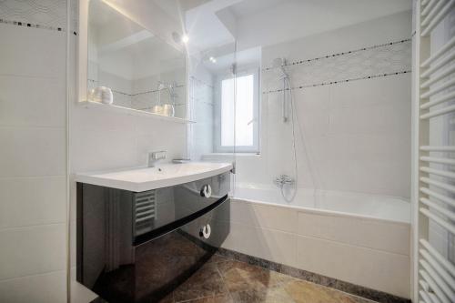 une salle de bain blanche avec un lavabo et une baignoire dans l'établissement 'JOLI 4 Pieces PROCHE VIEUX PORT' - A3B75, à Cannes