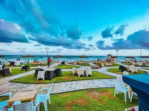 a patio with tables and chairs on the beach at Renovated super Lux Apartment Chalet Direct sea view 2 bed rooms in Alexandria Al Mamourah شاليه الترا لوكس شاطىء المعموره الاسكندريه دور اول على البحر مباشره مع كارنيهات الدخول طوال السنه و الشاطىء الخاص من اول مايو لنهايه اكتوبر للعائلات فقط in Alexandria