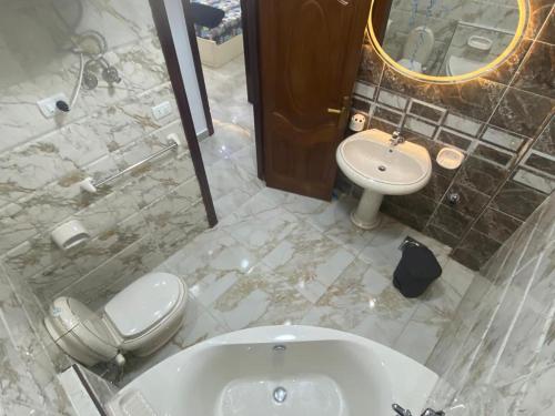 y baño con bañera, aseo y lavamanos. en Renovated super Lux Apartment Chalet Direct sea view 2 bed rooms Al Mamourah شاليه الترا لوكس شاطىء المعموره دور اول على البحر مباشره مع كارنيهات الدخول طوال السنه و الشاطىء الخاص من اول مايو لنهايه اكتوبر للعائلات فقط en Alexandria