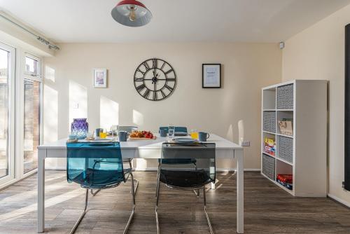 kuchnia ze stołem i krzesłami oraz zegarem na ścianie w obiekcie DUDLEY by HOSPITAL - 3Bed - PARKING - Long stay - CONTRACTORS w mieście Woodside