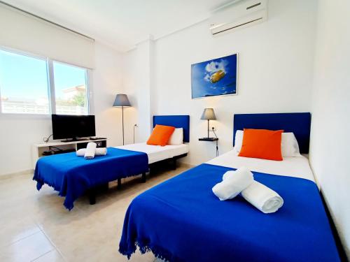 ein Schlafzimmer mit zwei Betten und einem Fernseher darin in der Unterkunft La Manga Norte Villa - 6509 in La Manga del Mar Menor