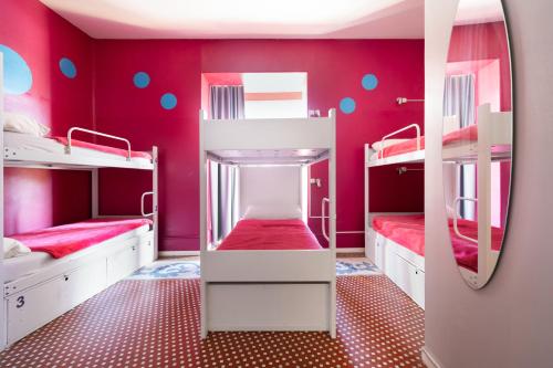 a room with two bunk beds and a mirror at Purple Nest Hostel in Valencia
