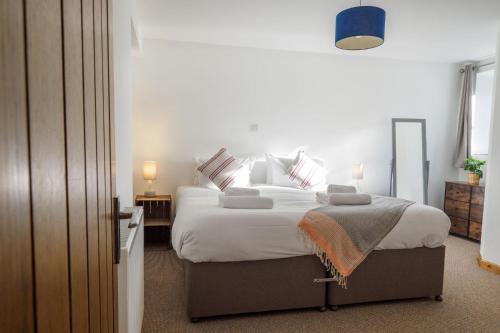 a bedroom with a large bed with white sheets and pillows at Manacles in Mawnan