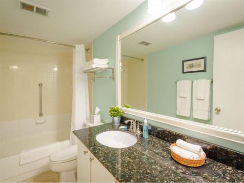 a bathroom with a sink and a toilet and a mirror at Laguna Reef #214 - Retreat on Rockport Bay in Rockport