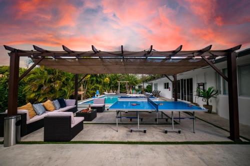 a patio with two tables and a pergola at Heated pool in a Precious House close to Zoo Parks and Arts in Cutler Bay