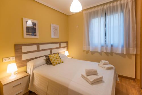 a bedroom with a bed with two towels on it at Apartagal-Costa Reinante Spa in Barreiros