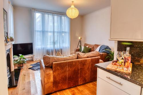 uma sala de estar com um sofá de couro castanho num quarto em DUDLEY - 1Bed - CORPORATE TRAVEL - PARKING - LONG STAYS em Dudley