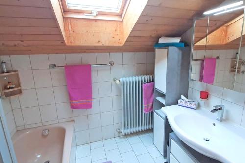 W łazience znajdują się różowe ręczniki, umywalka i wanna. w obiekcie Ferienwohnung Schäffer w mieście Aschau im Chiemgau