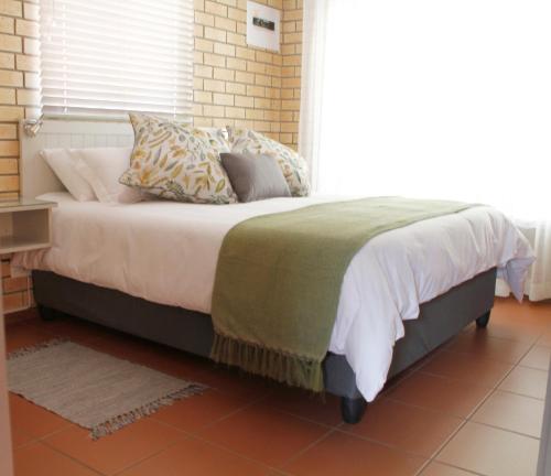 uma cama num quarto com uma grande janela em Vita Nova em Bloemfontein
