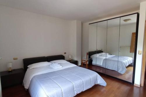 - une chambre avec 2 lits et un grand miroir dans l'établissement Casa Pie' di Monte, à Bisegna