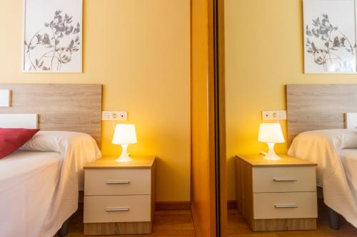 a bedroom with two twin beds and two lamps at Apartagal-Costa Reinante Spa in Barreiros