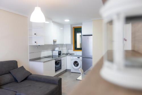 a living room with a couch and a kitchen at Apartagal-Costa Reinante Spa in Barreiros