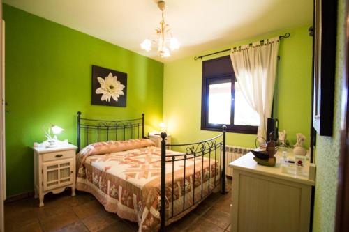 een slaapkamer met groene muren, een bed en een raam bij Catalunya Casas Peaceful Perfection , only 30km from Barcelona! in Vacarisas