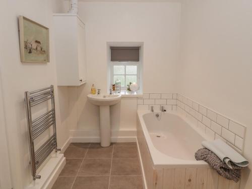 Cornhill-on-tweed的住宿－Cherry Studio，白色的浴室设有水槽、浴缸和卫生间。