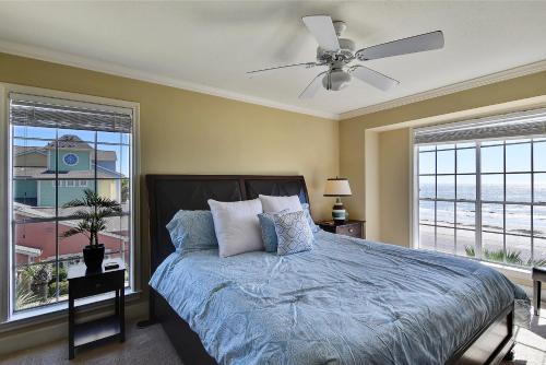 1 dormitorio con 1 cama, ventilador de techo y ventanas en Dawn 631 en Galveston