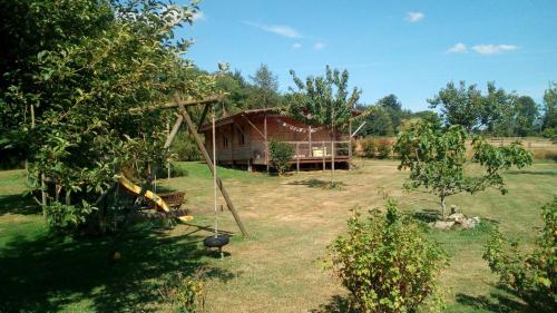 une maison au milieu d'une cour arborée dans l'établissement Gîte Normand Le Merle blanc 2 à 6 personnes, 