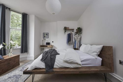 um quarto com uma cama com lençóis brancos e almofadas em DUDLEY 2-BED Luxury - Spacious - Parking em Dudley