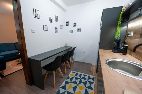 a bathroom with a sink and a counter with chairs at Angelina Apartment in Bitola