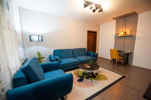 a living room with a blue couch and a table at Angelina Apartment in Bitola