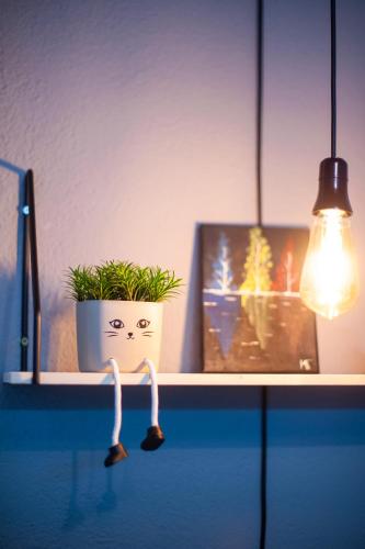 a shelf with a potted plant and a light at Angelina Apartment in Bitola