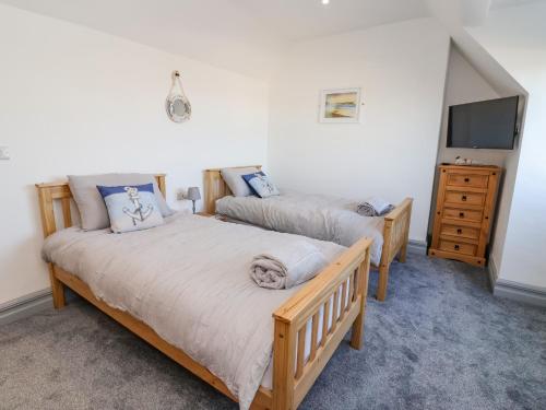 Habitación con 2 camas individuales y TV. en Sea Spell Loft en Hornsea